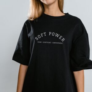 Black women’s t-shirt with minimalist “Soft Power” text – Teesora statement tee for confident women.